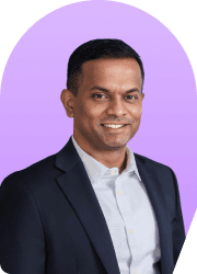 Headshot of a smiling man in a suit against a purple background.
