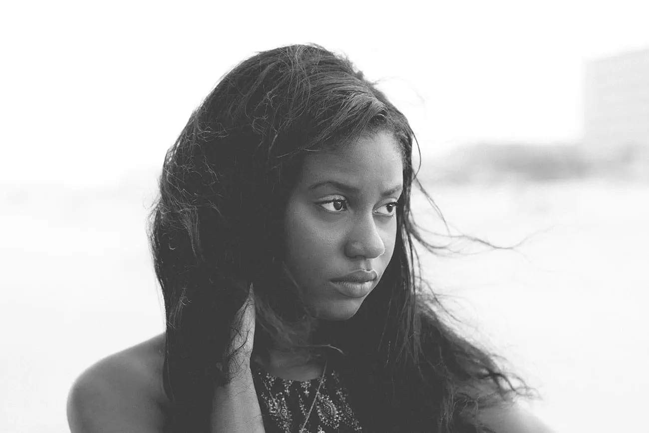 Thoughtful young woman with long hair looking away