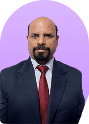 Headshot of a man in a suit and red tie against a purple background.